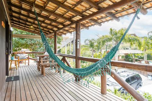 a hammock on the deck of a house at Recanto das Palmeiras in Guarda do Embaú