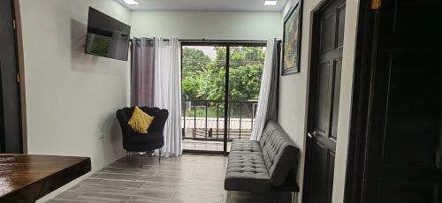 a hallway with a chair and a door with a balcony at APARTAMENTOs HABY 2 in Paquera