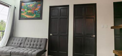 a room with two black doors and a couch at APARTAMENTOs HABY 2 in Paquera