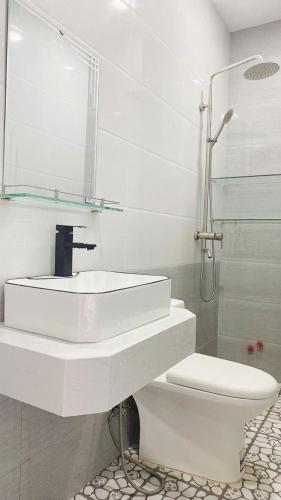 a white bathroom with a sink and a toilet at Khánh An Hotel in Nha Trang