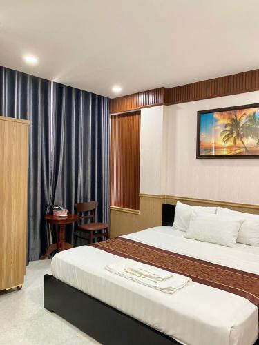 a hotel room with two beds and a chair at Khánh An Hotel in Nha Trang