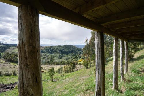 a view from the porch of a house with wooden beams at Cabañas San José in Quilquico