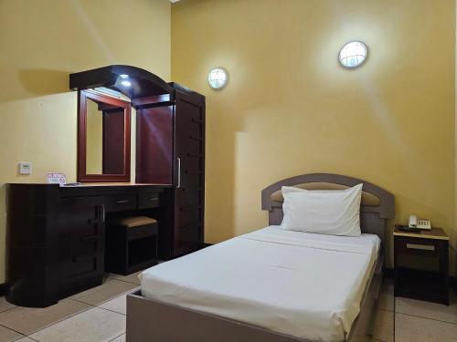 a bedroom with a bed and a dresser and a mirror at Hotel Nicanor in Dumaguete