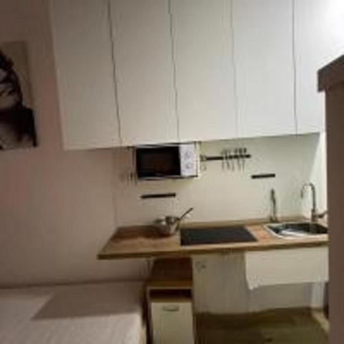 a small kitchen with white cabinets and a sink at MINATO Apartments Ostrava center in Ostrava