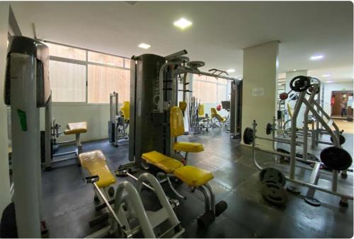 a gym with tread machines and yellow chairs in it at Apartamento joia rara no coração do Sudoeste in Brasilia