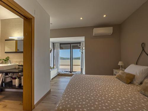 a bedroom with a bed and a bathroom with a sink at Villa Mar & Natura Sitges in Canyelles