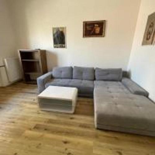 a living room with a blue couch and a table at MINATO Apartments Ostrava center in Ostrava