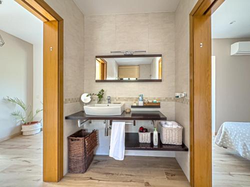 a bathroom with a sink and a mirror at Villa Mar & Natura Sitges in Canyelles