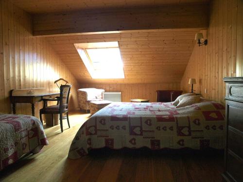 a bedroom with a bed and a table in a room at Auberge De La Charriole in Taintrux