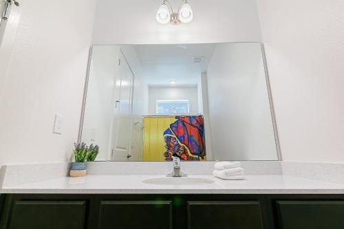 a bathroom with a sink and a large mirror at ☀️12BR Disney Villa Paradise w/ Game Room & Pool/Spa☀️ in Kissimmee