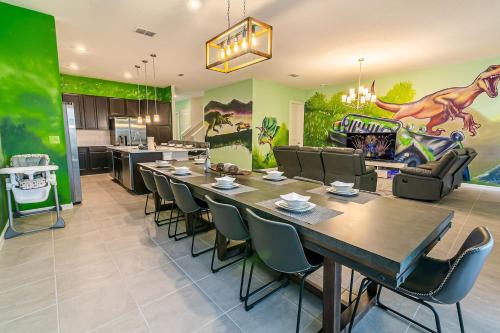 a dining room with a large table and a kitchen at ☀️12BR Disney Villa Paradise w/ Game Room & Pool/Spa☀️ in Kissimmee