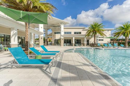 a swimming pool with lounge chairs and a hotel at ☀️12BR Disney Villa Paradise w/ Game Room & Pool/Spa☀️ in Kissimmee
