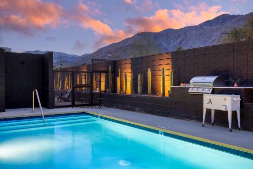 a house with a swimming pool with mountains in the background at Blackhaus Suites by AvantStay Modern Comfort in Downtown Palm Springs in Palm Springs