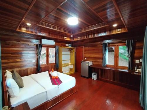 a bedroom with a white bed in a wooden room at Kohjum Seafront Resort in Ko Jum