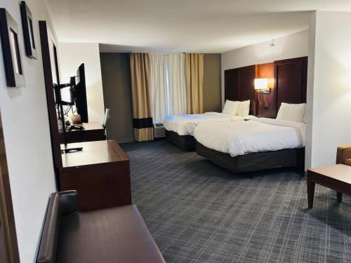 a hotel room with two beds and a couch at Comfort Suites Plymouth near US-30 in Plymouth