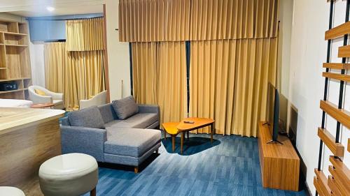 a living room with a couch and a television at De Balen Soultan Hotel in Puyung
