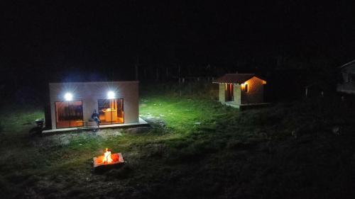 a small cabin with a fire in the yard at night at Refugio Sereno in El Manzano