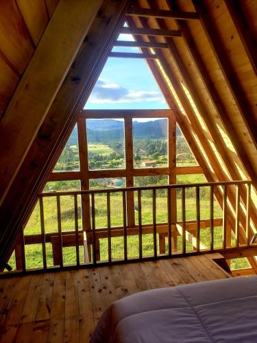 a room with a large window in a cabin at La Alejandría de Guasca in Guasca