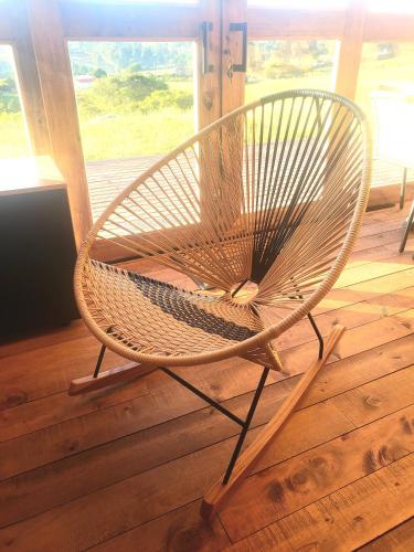 a wicker chair sitting on top of a wooden floor at La Alejandría de Guasca in Guasca