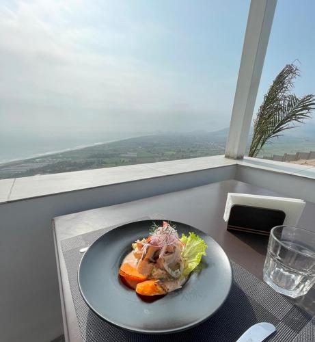a plate of food sitting on a table in a window at Vista a Mar in Huaral