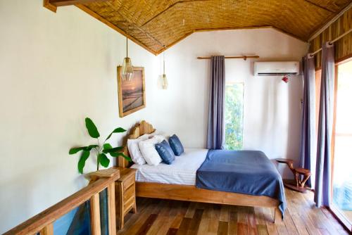 a bedroom with a bed with blue blankets and pillows at Krui Surfing in Wainapal