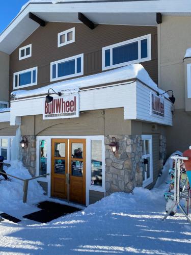 a building with a sign that reads bull wheeler at 3 BR 3 Bath ski in ski out with private hot tub in Big White
