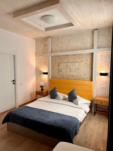 a bedroom with a large bed and a brick wall at Casa Teo in Mahmudia
