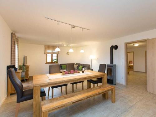 a dining room and living room with a table and chairs at in the holiday home Vorbergblick in Reichersbeuern