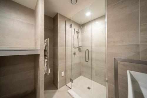 a shower with a glass door in a bathroom at Residence du Parc - Luxury Apartment in Queenstown