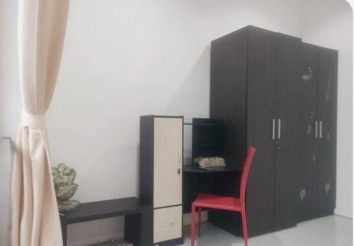a bedroom with a black cabinet and a red chair at Cheery Home Surabaya 10 mins toll near Pakuwon Mall in Surabaya