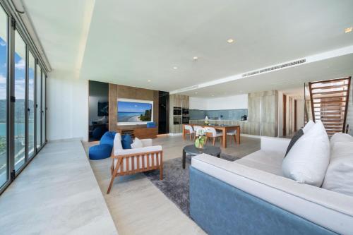 a living room with a couch and a table at Ocean Bliss - Sapphire Bay 3BR Apartment 812 with Terrace and Awe-Inspiring Views of Patong Bay in Patong Beach