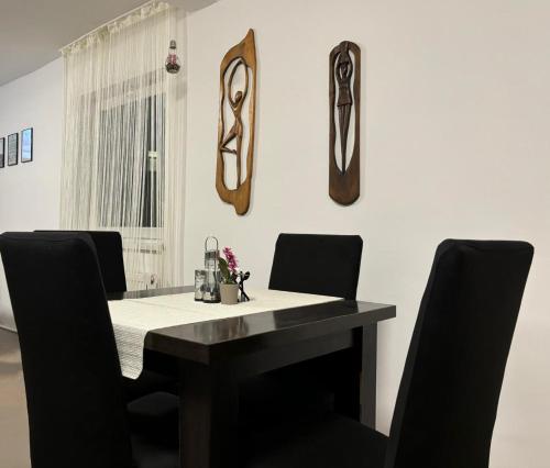 a dining room with a black table and chairs at Vila Eden Azuga in Azuga