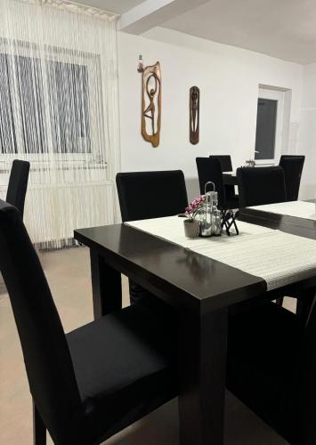 a dining room with a black table and black chairs at Vila Eden Azuga in Azuga