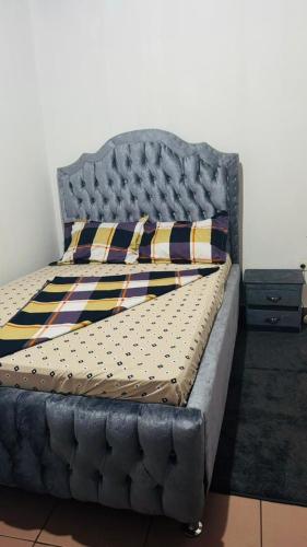 Ce lit se trouve dans un dortoir doté d'un cadre gris. dans l'établissement Sacha appartement 2 chambres, à Yaoundé