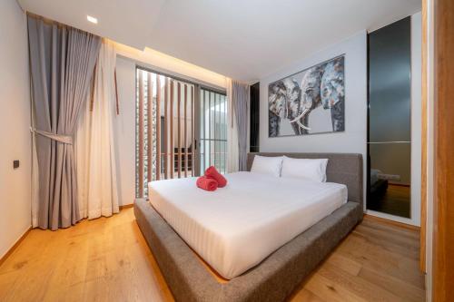a bedroom with a large white bed with a red pillow at Ocean Bliss - Sapphire Bay 3BR Apartment 812 with Terrace and Awe-Inspiring Views of Patong Bay in Patong Beach