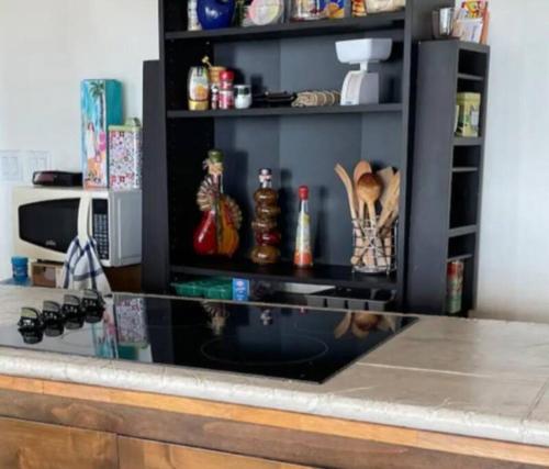 a kitchen counter with a shelf with items on it at Hermoso departamento con vista al mar y privado in La Playita