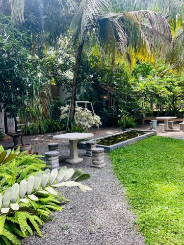 a park with a bench and a table in the grass at Krishan Villa in Negombo