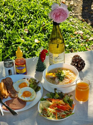 a table with plates of food and a bottle of wine at Charlee Khaoyai in Mu Si