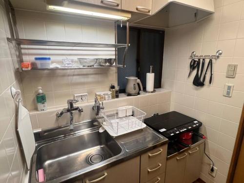 a kitchen sink with a dish drying rack next to it at 旅の宿hitotoki in Tokyo