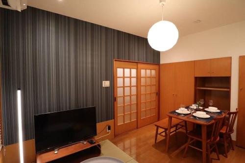 a living room with a table and a television at 旅の宿hitotoki in Tokyo