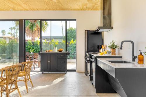a kitchen with a sink and a counter at Blackhaus Suites by AvantStay Modern Comfort in Downtown Palm Springs in Palm Springs