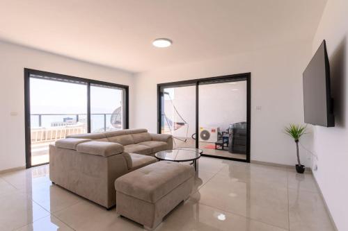a living room with a couch and a table at לוי-קיישן מגוון דירות גן ופנטהאוזים וסוויטות נוף ברחוב הצנחנים in Tiberias