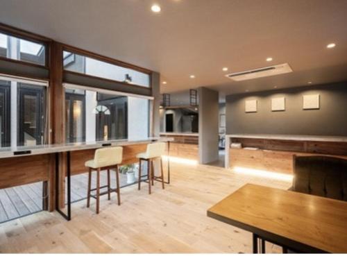a kitchen with a bar with chairs and tables at ODEON Gongen松山市一組限定貸切グランピング in Horiechō