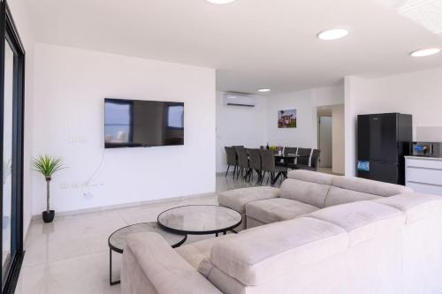 a living room with a couch and a table at לוי-קיישן מגוון דירות גן ופנטהאוזים וסוויטות נוף ברחוב הצנחנים in Tiberias