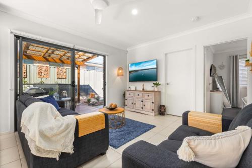 a living room with two couches and a tv at The Bayswood Retreat on Moona Creek by Experience Jervis Bay in Vincentia