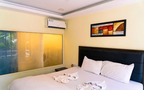 a bedroom with a bed with two towels on it at Village Susegat Beach Resort in Morjim