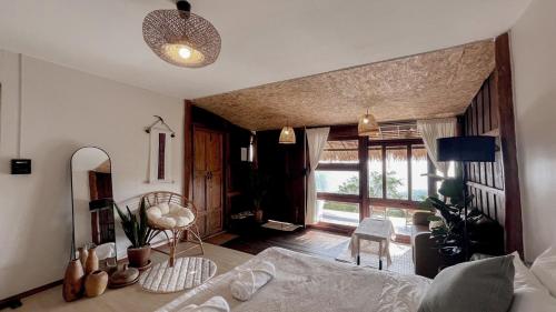 a living room with a bed and a large window at ซือรี ก๊ะฉิ - Suri Kachi ที่พักดอยช้าง in Ban Huai Khai