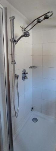 a bathroom with a shower with a shower head at Saroja Plus in Brand