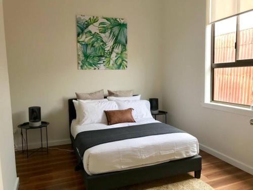 a bedroom with a bed with a picture on the wall at D109 Inner City Oasis on Buckingham in Melbourne