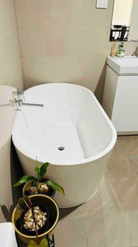 a bathroom with a white tub and a potted plant at D109 Inner City Oasis on Buckingham in Melbourne